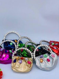 a group of colorful handbags with crystals on them